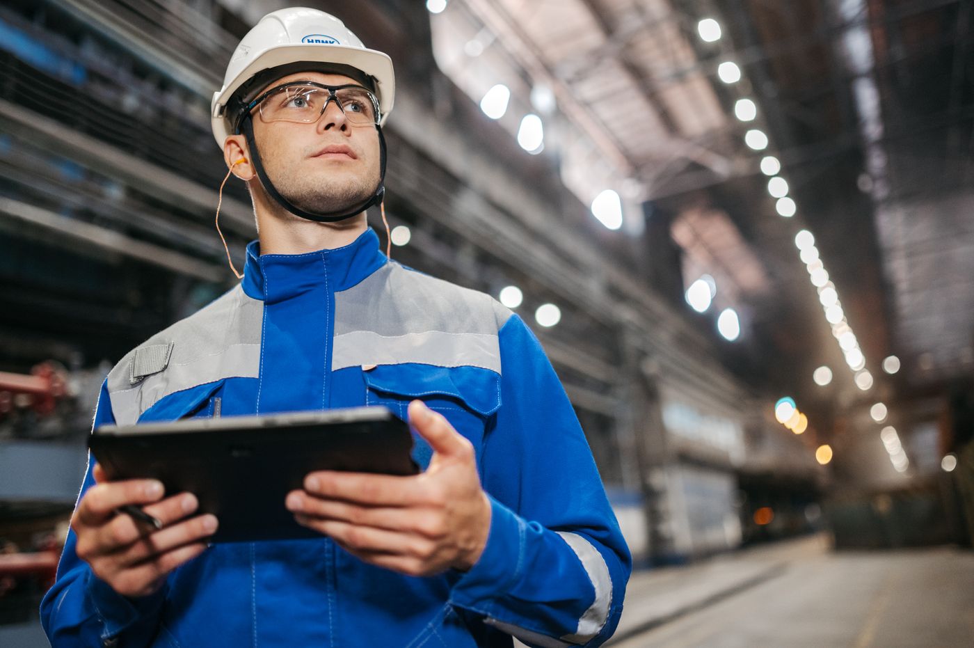 Plant operator in safety gear using a tablet